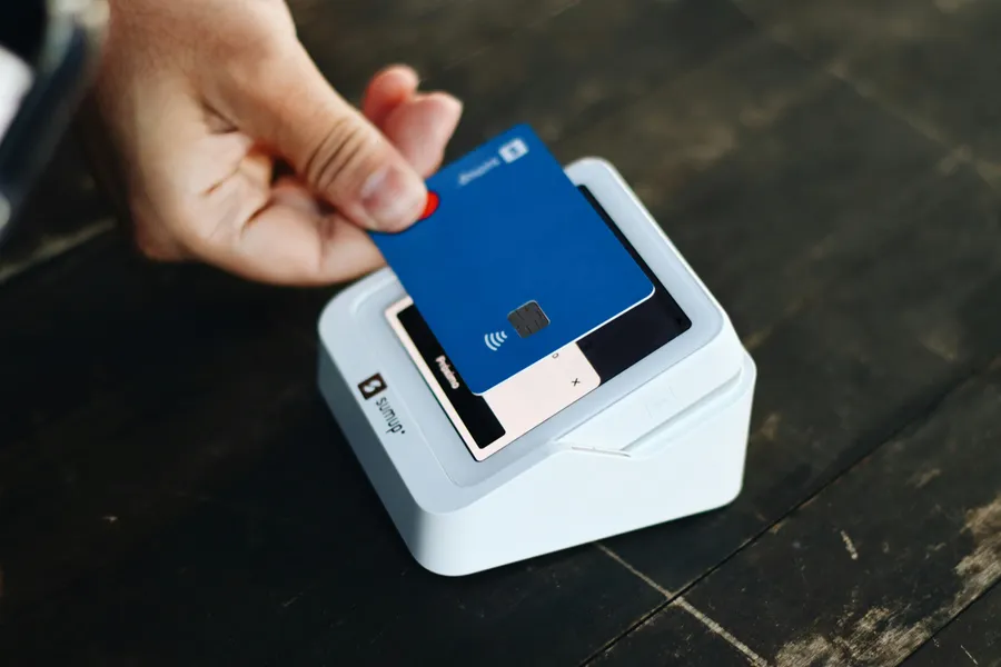 Main qui paie avec une carte sans contact sur un terminal